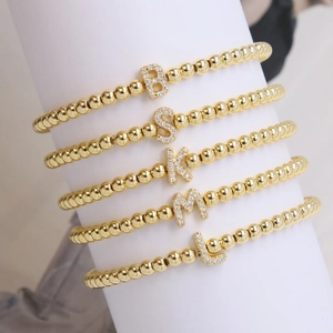 Five-piece set of 18k gold plated beaded bracelets with micro-pave letter charms