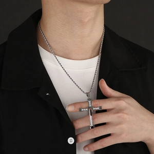 Detail of silver stainless steel cross pendant with crystals on a twist chain necklace