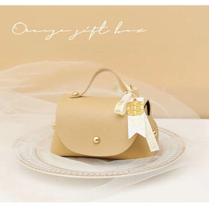 Detail view of beige leather wedding gift box with gold studs and elegant ribbons
