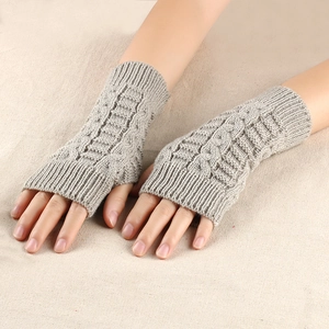 Detailed cable knit pattern on light grey fingerless gloves with ribbed cuffs