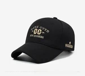 Detail of black baseball cap featuring gold embroidered letters and star on cotton fabric