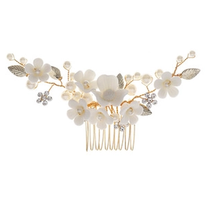 Detalle de flores de cerámica blanca y perlas en un peine para cabello dorado