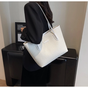 Detail of white woven texture tote bag with leather handle carried by a professional model