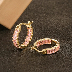 Close-up of gold hoop earrings with pink baguette-cut zircons and secure snap closure