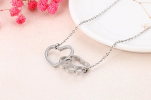 Detailed view of silver cat paw heart pendant interlocking on a fine link chain