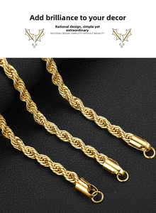 Macro detail of three golden stainless steel rope chains with lobster clasp on black texture