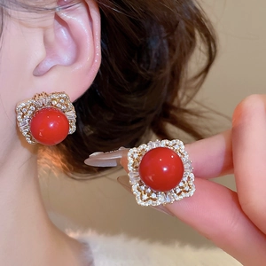 Detail of vintage square gold earrings featuring red resin center and micro-pave zircons