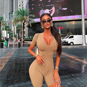 Outdoor shot of khaki bodycon short sleeve romper with deep V-neck on a model
