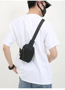 Back view of a man wearing a compact black waterproof chest bag with adjustable strap