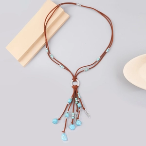Detail view of Bohemian long necklace with turquoise beads, suede cord, and metal feathers