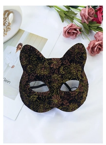 Close-up of black cat mask with intricate gold floral patterns and red detailing