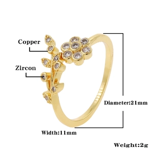 Macro detail of gold flower ring featuring cubic zirconia petals and leaf design