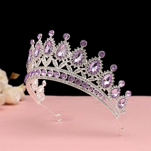 Dettaglio di un diadema in argento con cristalli viola su una base rosa tenue