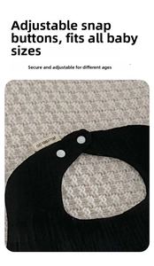Detail of black cotton gauze baby bib with wavy edges and adjustable white snap button