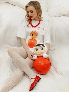 Λεπτομέρεια λευκού oversized βαμβακερού T-shirt με vintage σχέδιο και κόκκινο κείμενο