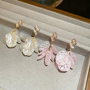 Floral shell earrings with zircon tassels in cream white and light pink finishes