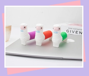 Three colorful llama pop tube sensory toys standing on a laptop for stress relief