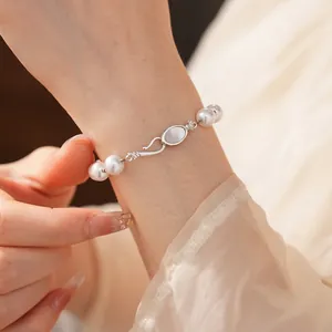 Elegant pearl bracelet with shell inlay and silver clasp on female wrist