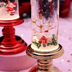 Macro shot of LED Christmas snow globe with miniature house and golden sparkles inside