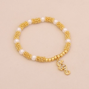 Macro detail of beaded bracelet with pearl accents and a pave zircon seahorse charm