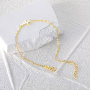 Detailed close-up of S925 sterling silver cross charm bracelet with gold plating and clasp