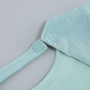 Close-up of mint green knitted fabric with metallic silver threads and shoulder strap detail