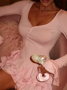 Detail of pink knitted mini dress with ruffled cuffs and button-down front slit
