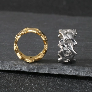 Dettaglio degli anelli in metallo pesante traforato con finiture in oro e argento