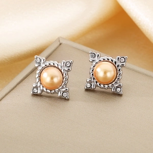 Detail showing square 18K gold plated earrings with pearl inlay and crystals