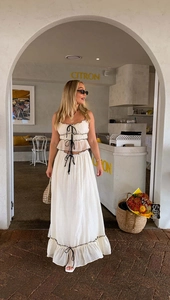 Detail of white two-piece set featuring black drawstring bows and ruffled fairy skirt edges