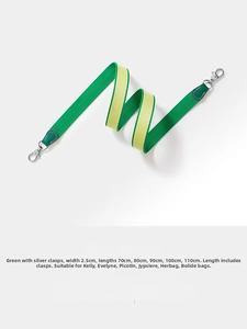 Detail of green and yellow canvas shoulder strap with silver hooks and leather ends