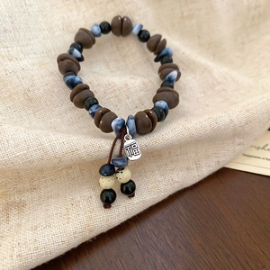 Detailed shot of coffee bean acrylic beads with a metallic Fu character charm tag