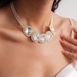 Elegant gold necklace featuring five large round crystals and sparkling rhinestone chains