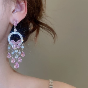 Close-up of pink butterfly tassel earrings with sparkling cubic zirconia on a model