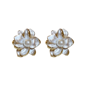 Elegant gold flower earrings with white enamel petals and central pearl on white background