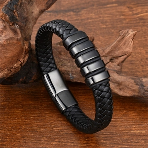 Close-up of woven black leather bracelet with magnetic buckle on natural wood