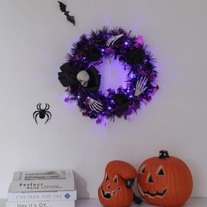 Detail of Halloween wreath with purple LED lights, black roses and skull hand accents