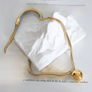 Modern gold plated snake chain necklace with polished sphere pendant on stone