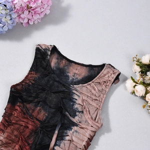 Detailed macro shot of textured tie-dye fabric with pleats in black and reddish brown