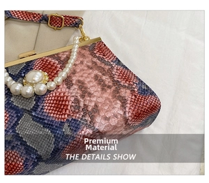 Détail du sac serpent rouge et bleu avec poignée en perles et cadre en métal doré