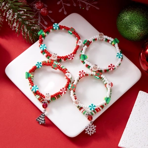 Christmas beaded bracelet set with clay charms and festive metal pendants on red background