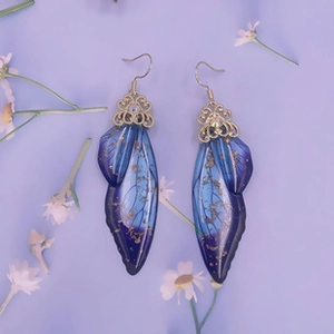 Detail of blue and purple gradient cicada wing earrings with gold foil inlays