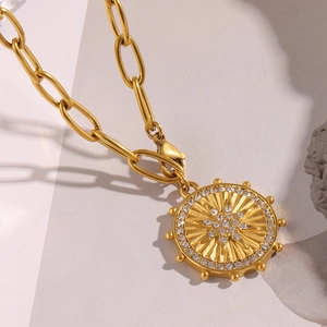 Detailed view of 18K gold plated paperclip chain with starburst coin pendant and crystals