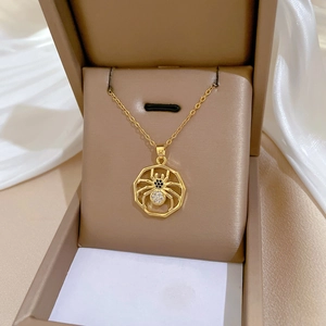 Gold spider necklace with zircon crystals in octagon frame displayed on silk padding