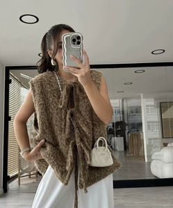 Detail of a brown mohair vest on a woman in a modern room with natural light