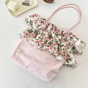 Dettaglio delle balze floreali e del materiale in tela sulla borsa tote retrò rosa