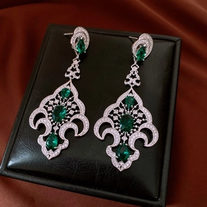 Détails de boucles d'oreilles vintage en argent avec pierres vertes et filigrane ajouré