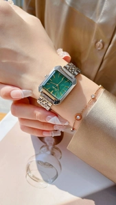 Silver square watch with emerald dial paired with a rose gold luxury bracelet