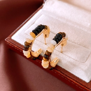 Macro shot of 18K gold plated hoop earrings with tiger eye and jade style beads