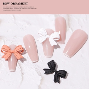 3D bow nail art charms in white pink and black finish on textured background